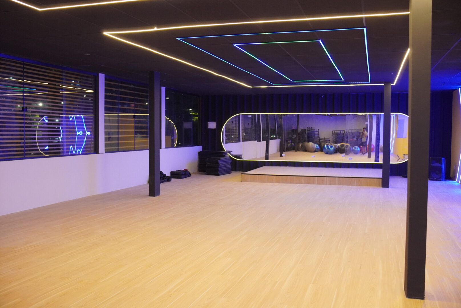 Estúdio de aulas coletivas com piso de madeira e iluminação em LED na unidade Abreu e Lima
