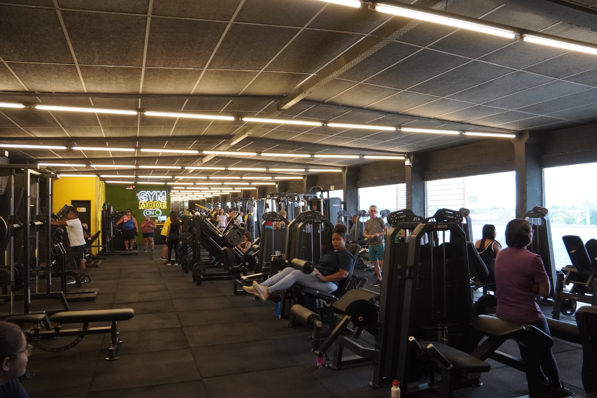 Ambiente amplo de musculação com painel Gym Mode On na unidade Paulista